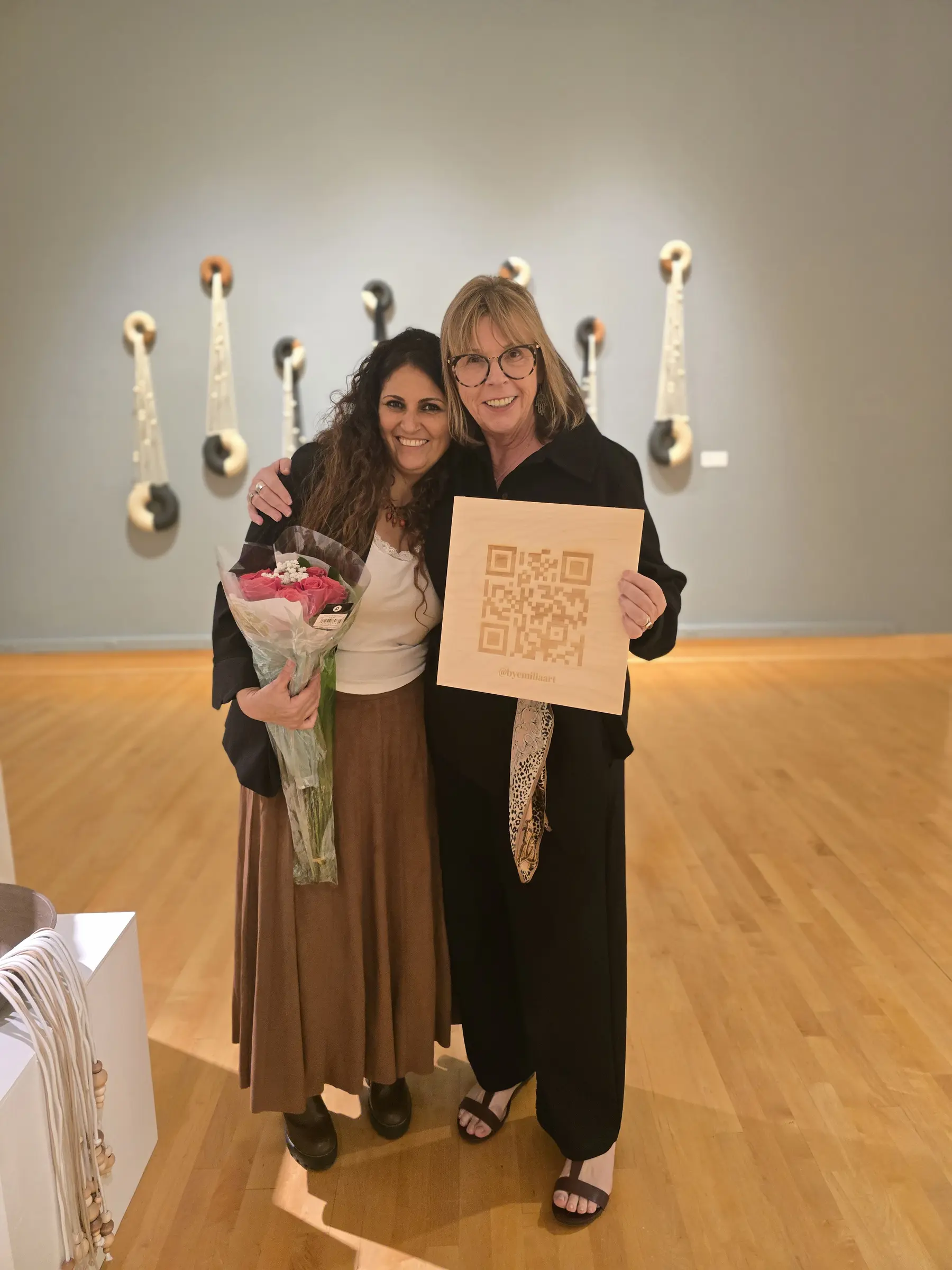 Two guests holding the exhibition information sign at the opening reception