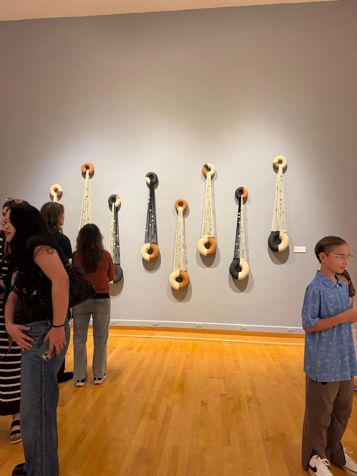 Guests gathered in front of the hanging ceramic and fiber installation