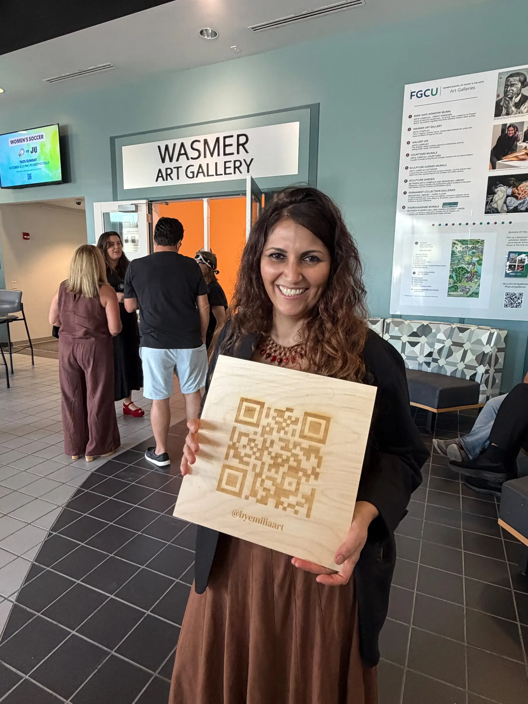 Maria Emilia Steiner holding the exhibition information sign