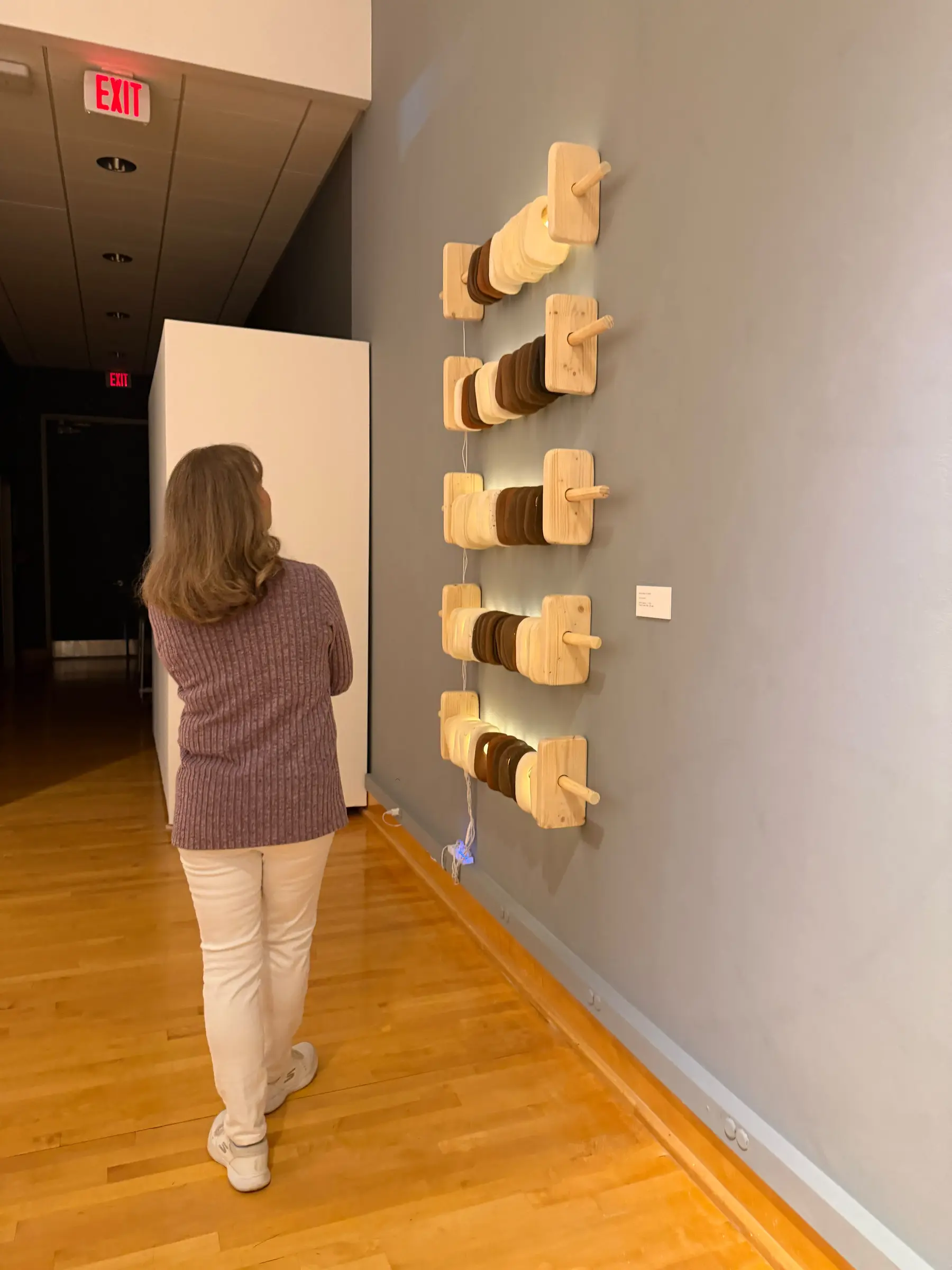 Visitor walking alongside the ceramic wall sculptures