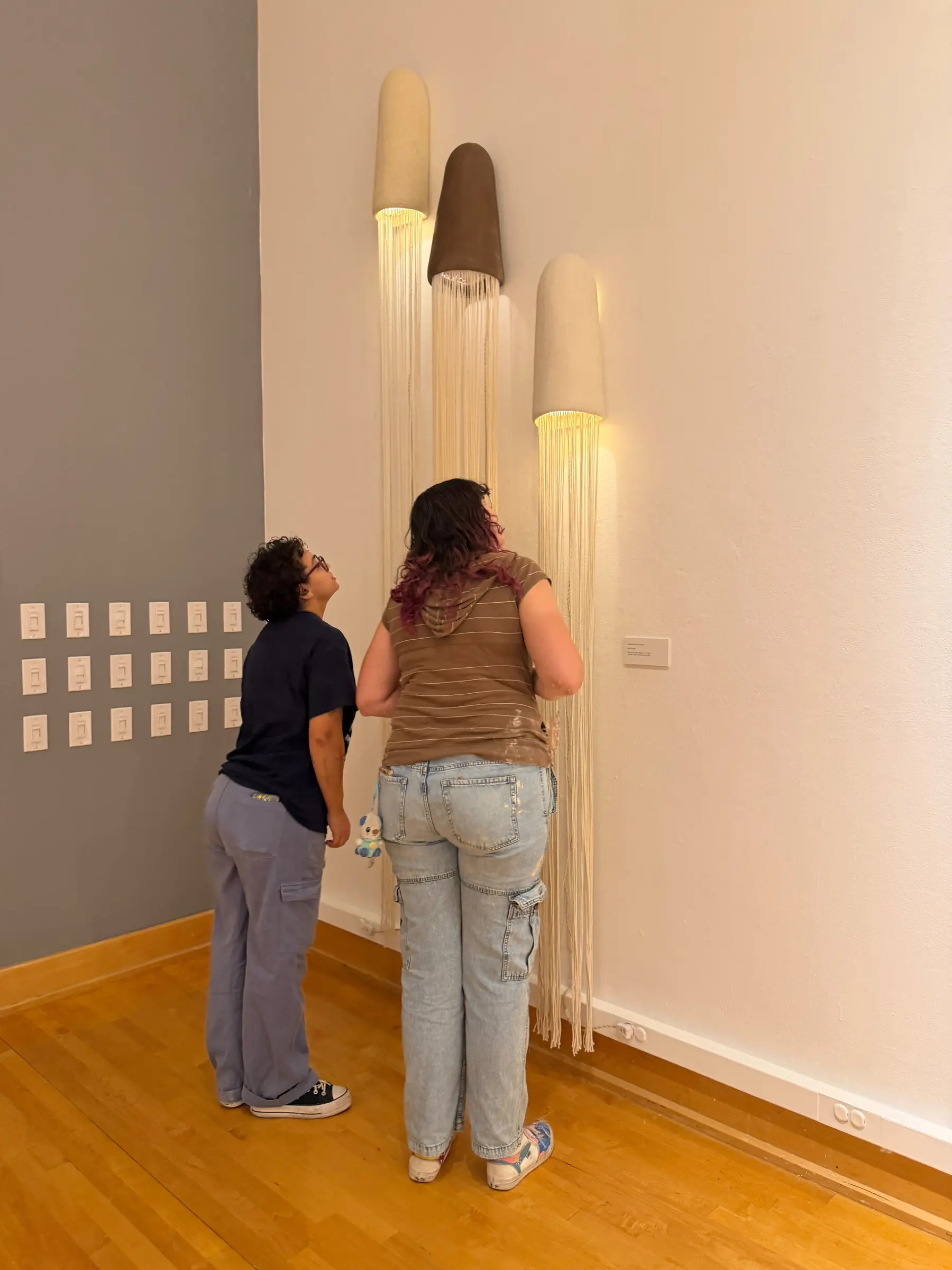 Two guests viewing the tall illuminated ceramic works