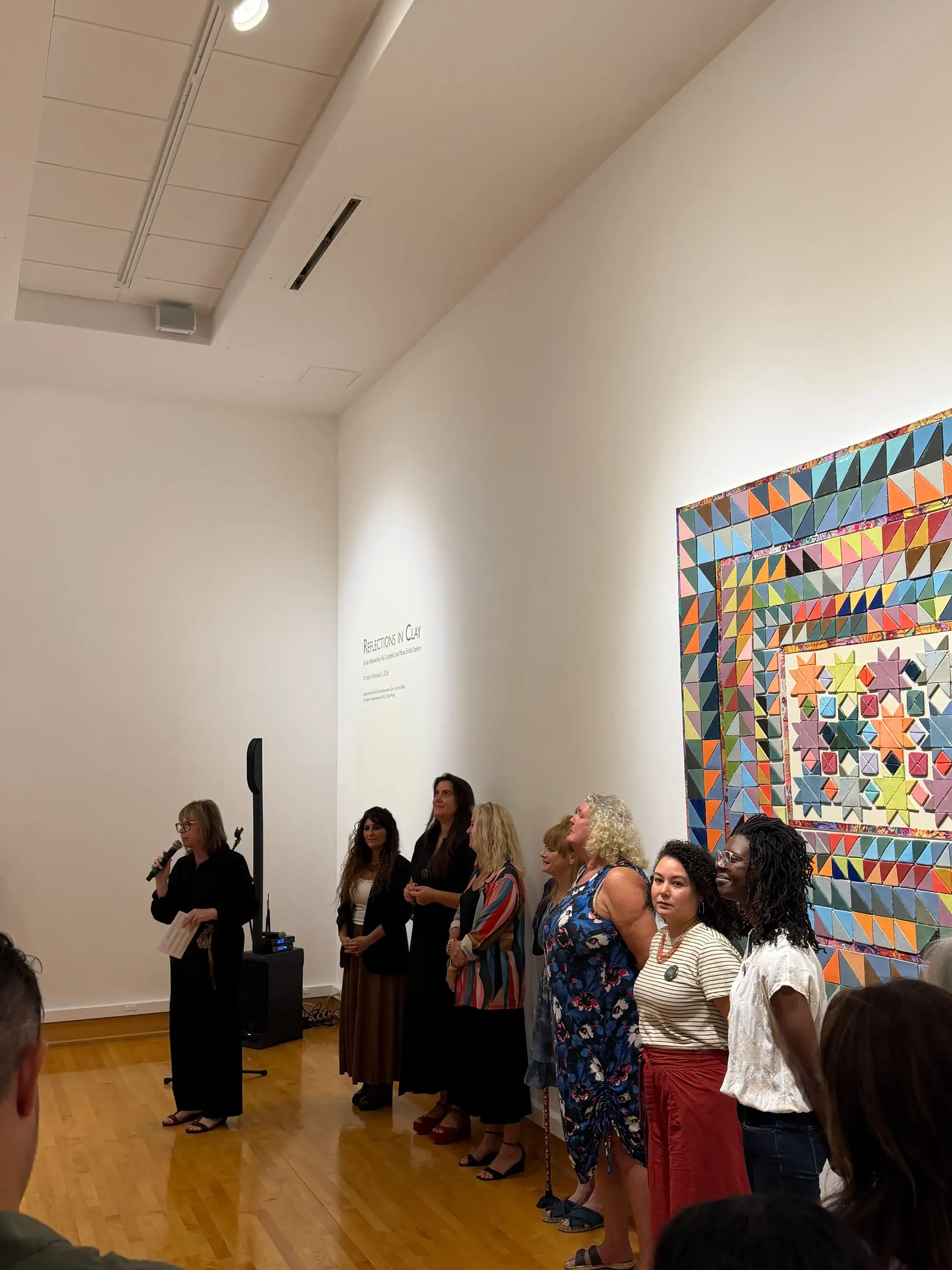 Artists speaking to the audience during the opening reception