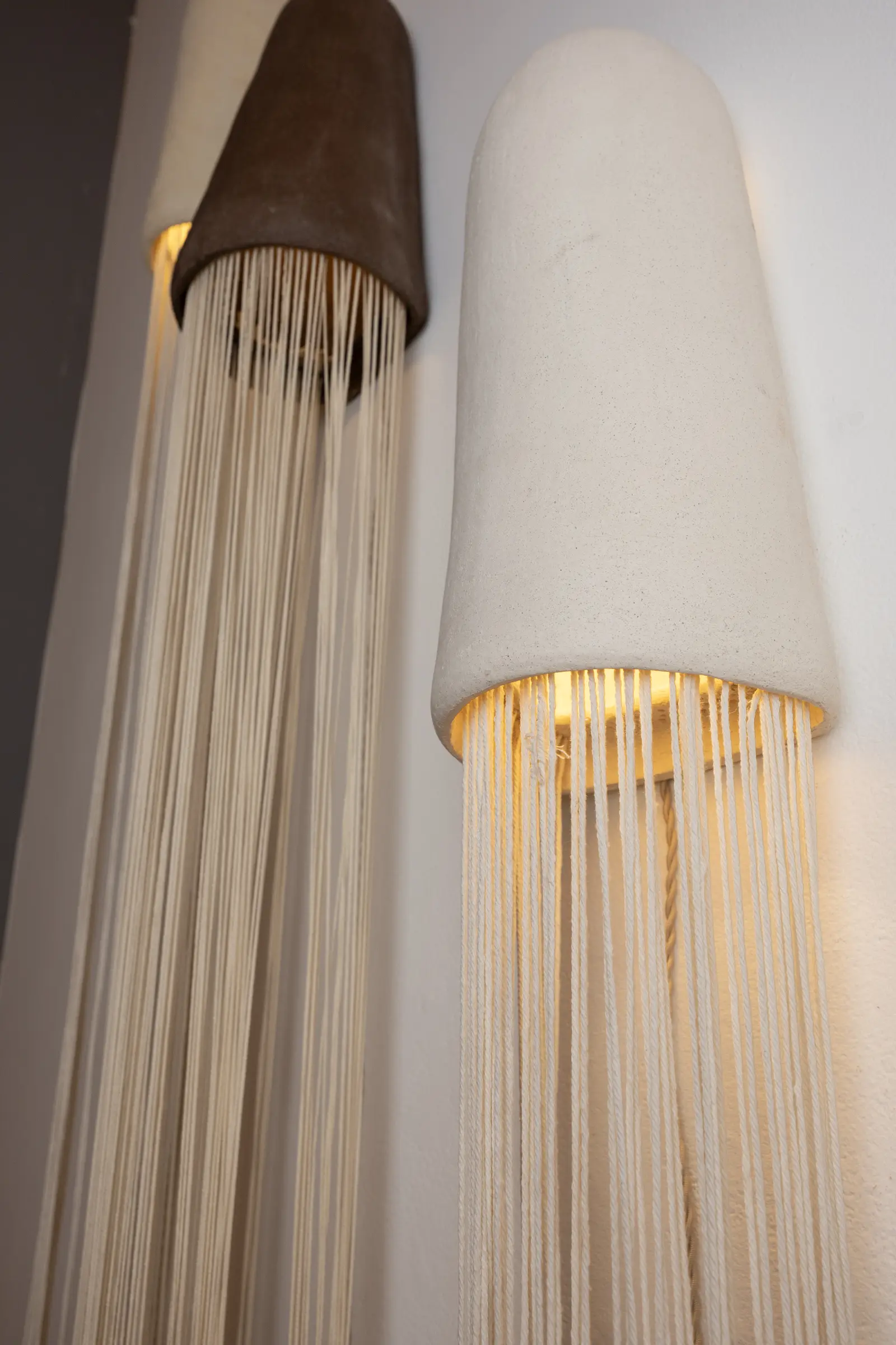 Close view of black and white ceramic lamps with long falling fiber