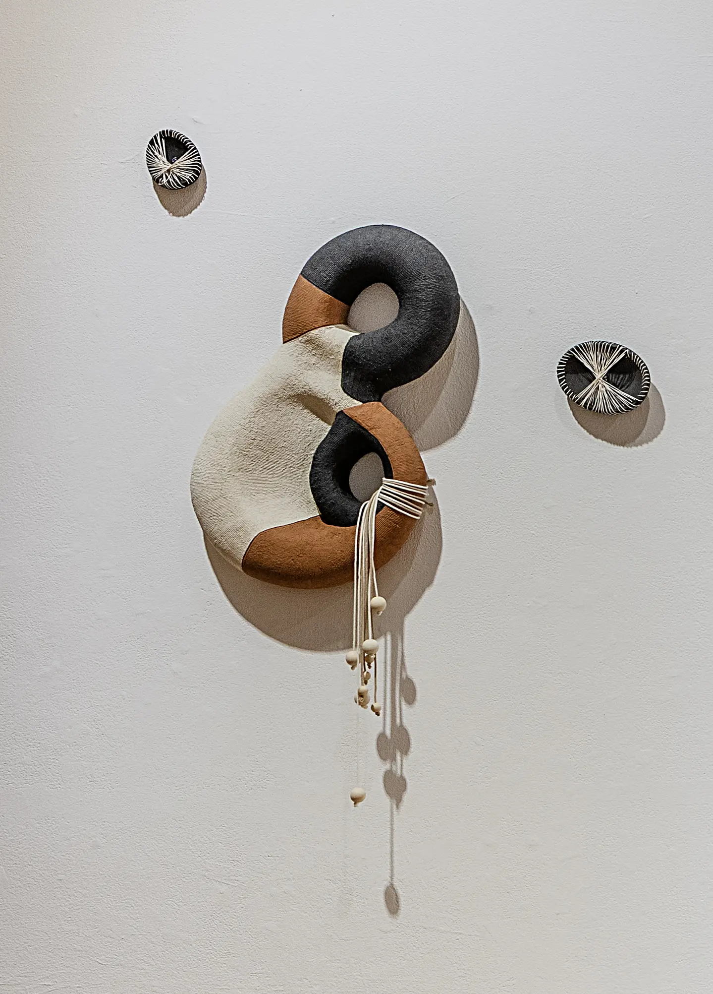 Close view of an interlocking brown, black, and white ceramic wall form