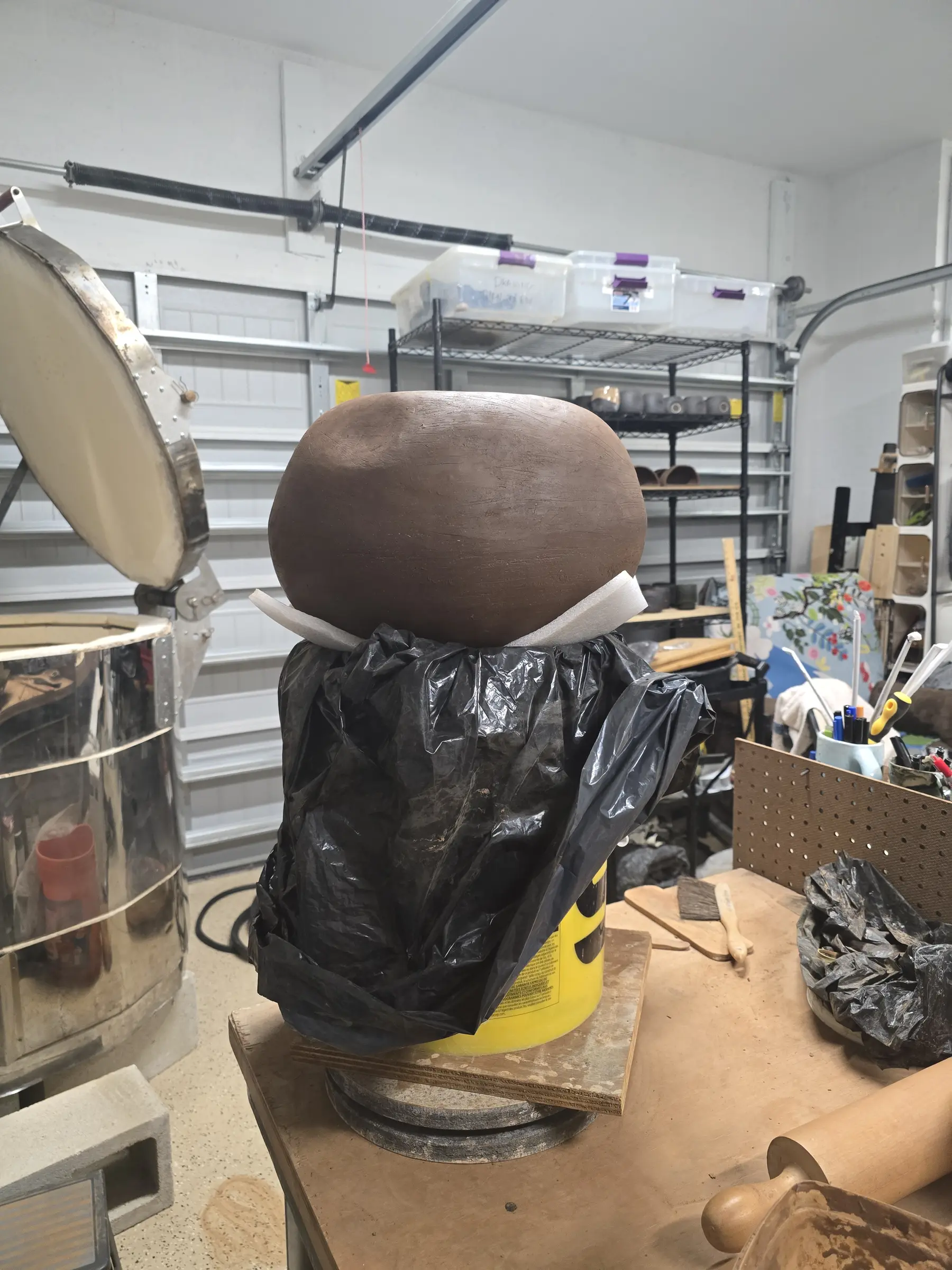 Large rounded clay form supported during construction