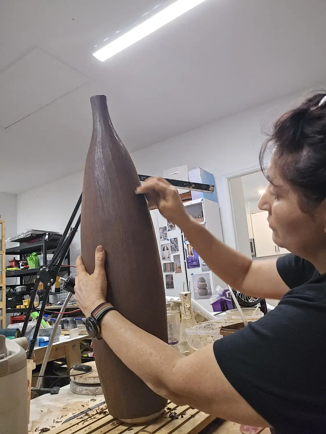 Maria shaping a tall clay sculpture by hand